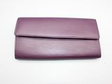 un sac à main violet posé sur une table blanche