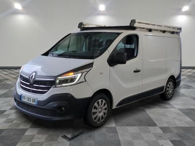 la camionnette blanche est garée sur le sol en damier d'un garage