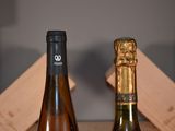 two bottles of wine sitting on a table next to each other