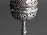 an old silver cup with a decorative design on the top of it