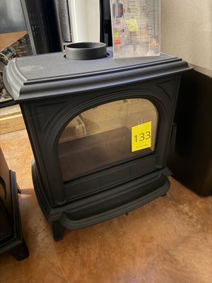 a black stove sitting next to a window in a room