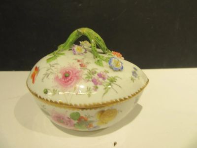 un bol blanc avec une anse verte et des fleurs dessinées dessus