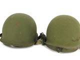 pair of army green helmets sitting on top of each other on a white surface