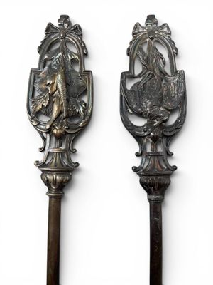 two spoons that are sitting side by side on a white surface