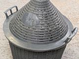 a large metal basket with a blue lid on the ground