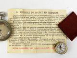 a small pocket watch and a small pocket watch on a piece of paper