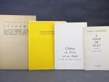 four books are lined up on a table with a black background