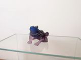 a figurine of a frog sitting on a glass table