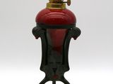 un vase rouge surmonté d'une couronne dorée
