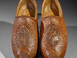 pair of wooden clogs with a carved design on the sole