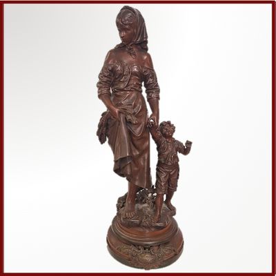 statue d'une femme avec un enfant et un chien, posée sur un socle