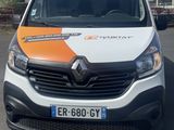 the front of a white van with an orange and white stripe parked in a parking lot