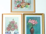 three framed paintings of flowers and fruit on a wall