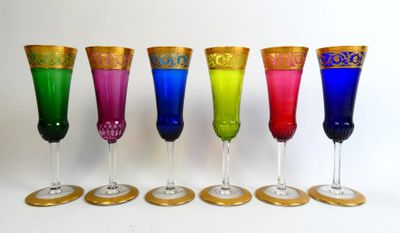 six different colored wine glasses lined up in a row on a white surface