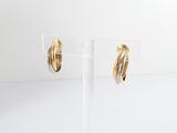 two tone gold hoop earrings on a clear stand