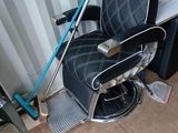 un fauteuil de coiffeur noir et blanc avec une poignée bleue