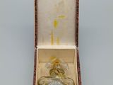 a small bottle of perfume in a box on a table