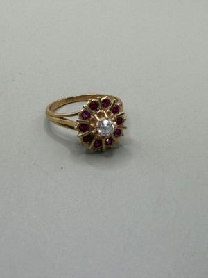 gros plan d'une bague en or avec des pierres rouges et blanches
