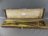 un vieux pistolet dans un coffret en bois sur fond gris
