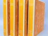 trois livres sont alignés les uns à côté des autres sur une surface bleue