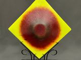 peinture représentant un diamant jaune au centre rouge sur un fond noir