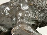 bronze statue of a lion on a rock with a white background