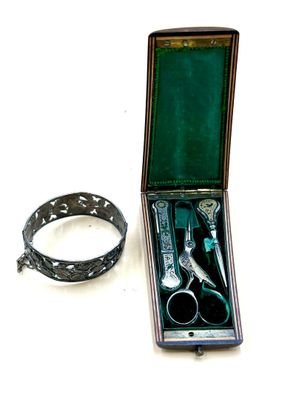 pair of scissors and a ring in a case on a white surface