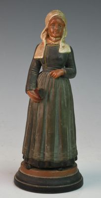 figurine of a woman in a green dress and bonnet