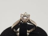a close up of a diamond ring on a black stand