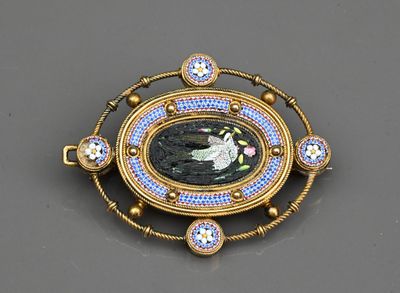 une image représentant une broche sur laquelle figure le portrait d'une femme