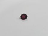 a red garnet stone on a white surface