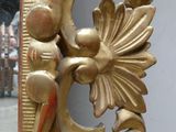a mirror that has a gold design on the side of it