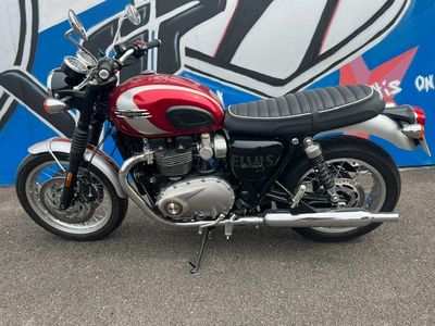 a red and black motorcycle parked in front of a blue and white sign