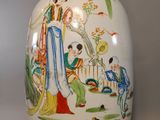 a white vase with a painting on it sitting on a table