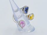a clear ring with three different colored stones on it