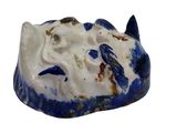 a small blue and white fish statue on a white surface