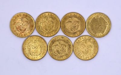 six types différents de pièces d'or posées sur une surface blanche