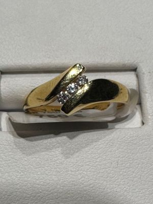 bague en or jaune sertie de diamants sur fond blanc