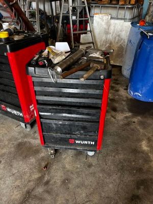 une boîte à outils rouge sur laquelle sont posés des outils, dans un garage