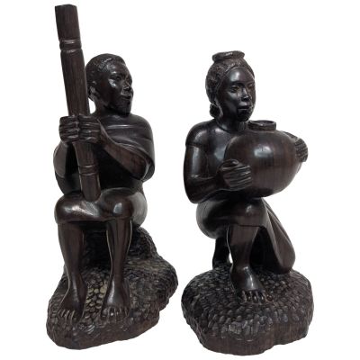pair of african figurines of a man and a woman holding instruments