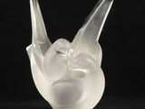 une image représentant une sculpture en verre représentant un oiseau sur fond noir