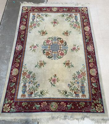 Un tapis chinois en laine à décor floral et d'un médaillon c…