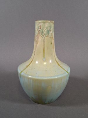 un vase blanc et bleu posé sur une surface grise