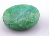 a close up of a green stone on a white surface