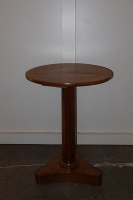 a small table with a wooden base in a room