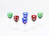 quatre verres à vin sont alignés sur une surface blanche