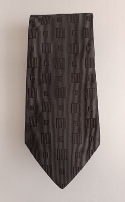 black and white striped neck tie hanging on a white wall