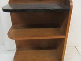 a wooden shelf with a glass top on a white floor