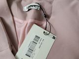 the label on a pink shirt is attached to the collar of the shirt