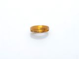 gros plan d'une bague en or sur une surface blanche